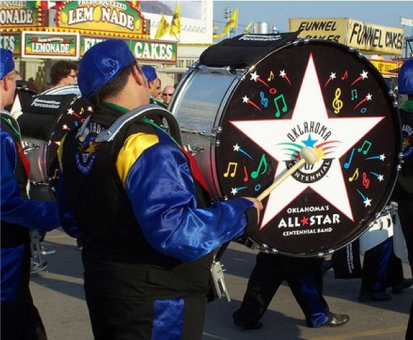 Marching drummer playing printed marching bass drum heads